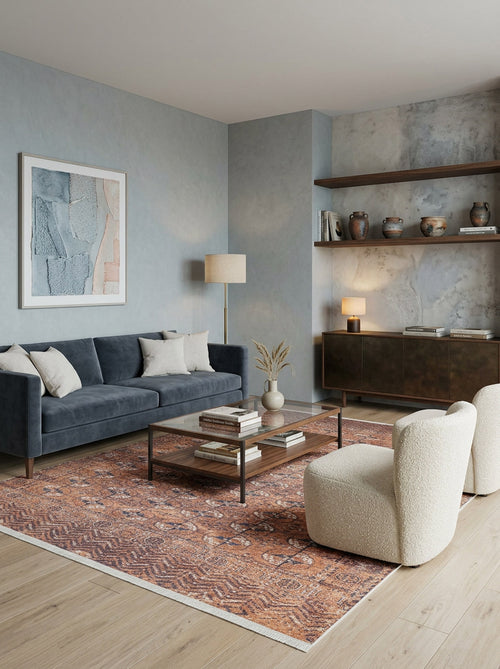 Load image 1 in gallery view. Modern living room with a blue-gray sofa, two white boucle chairs, the Earthy Enigma - Washable Rug - JR1937 ideal for high-traffic areas, a glass coffee table, wall art, pottery on shelves, and soft lighting for a cozy vibe.
