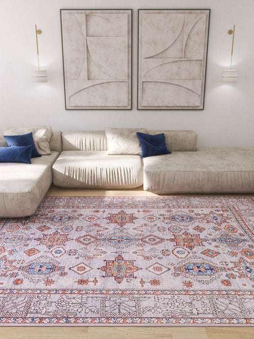 Load image 1 in gallery view. A modern living room with a cream sectional sofa, blue pillows, the Echelon Bordered Washable Rug - LCC3018 in gray-anthracite for high-traffic areas, abstract wall art, and wall-mounted light fixtures.