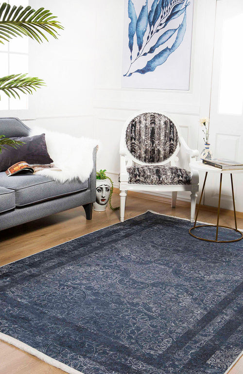 Load image 1 in gallery view. A stylish living room featuring a gray sofa, white fur throw, artistic chair, round side table with vase, large Elegant and Modern - Washable Rug - JR1297 (Custom Size) ideal for high-traffic areas, decorative face planter, and blue leaf wall art.