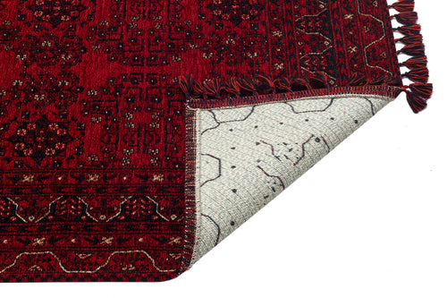 Load image 1 in gallery view. The Ember Stitch - Washable Kilim - BHR02 is a red patterned Turkish rug with fringed edges and a geometric border. One corner is flipped, showing the light-colored underside with a distinct pattern. The background is white.