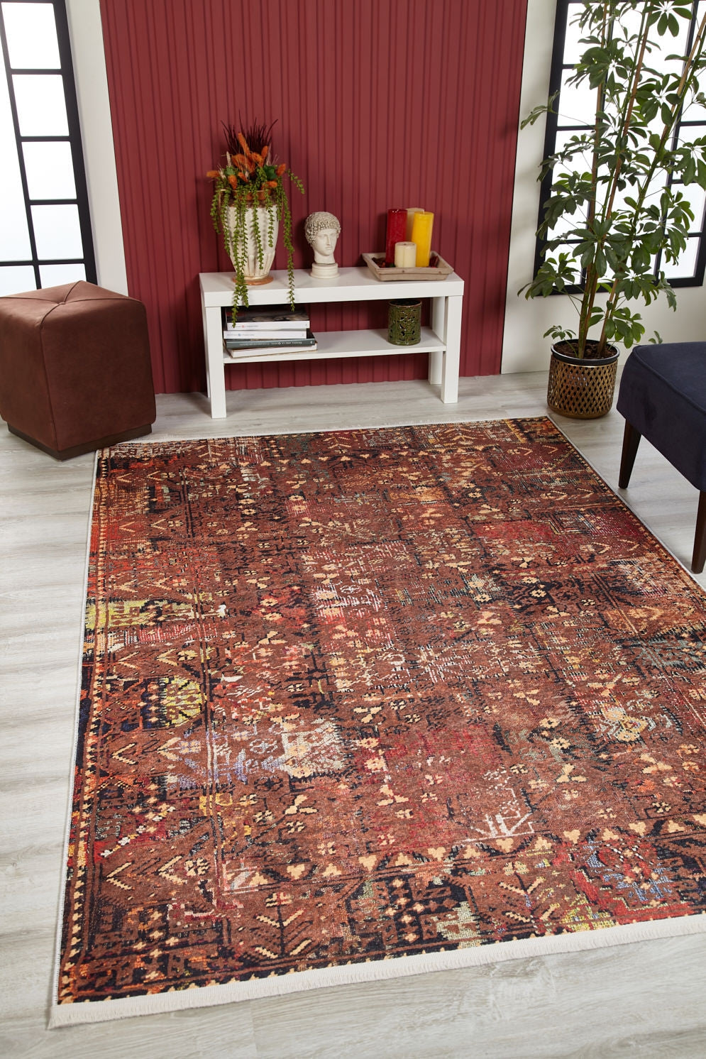 A living room with the Ethereal Elegance - Washable Rug - JR1651 in bronze and brown on light wood floors, a white console table, plants, red accent wall, and black-and-white windows—perfect for allergy-sensitive homes.
