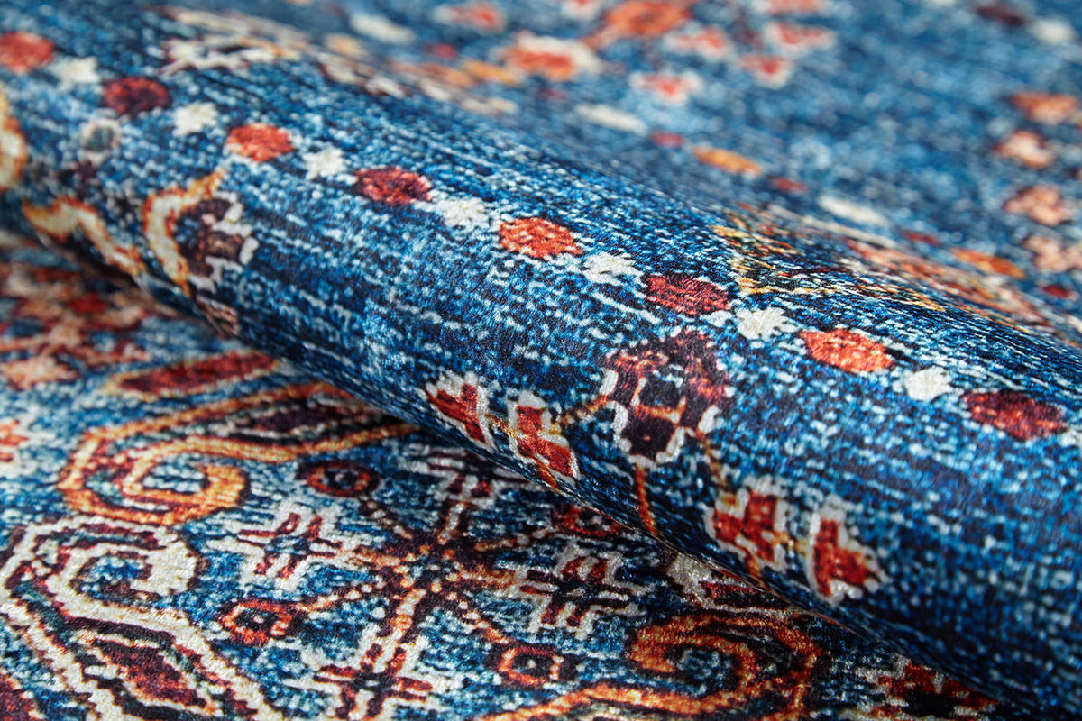 A close-up of the Ethereal Essence - Washable Rug - JR5087 (Custom Size) showcases Persian-inspired geometric patterns in blue, orange, white, and brown. Its intricate details and rich colors create a textured look—ideal for high-traffic areas.