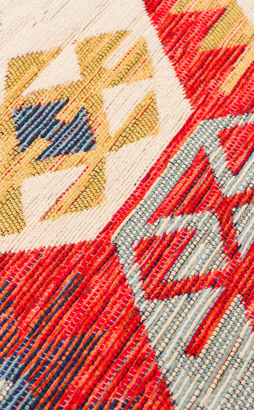 Bild 1 in Galerieansicht laden. Close-up of the "Ethnic Mix - Kilim - NMD01" rug, featuring multicolour geometric patterns and tribal motifs in red, yellow, blue, and cream with visible texture and intricate stitching.