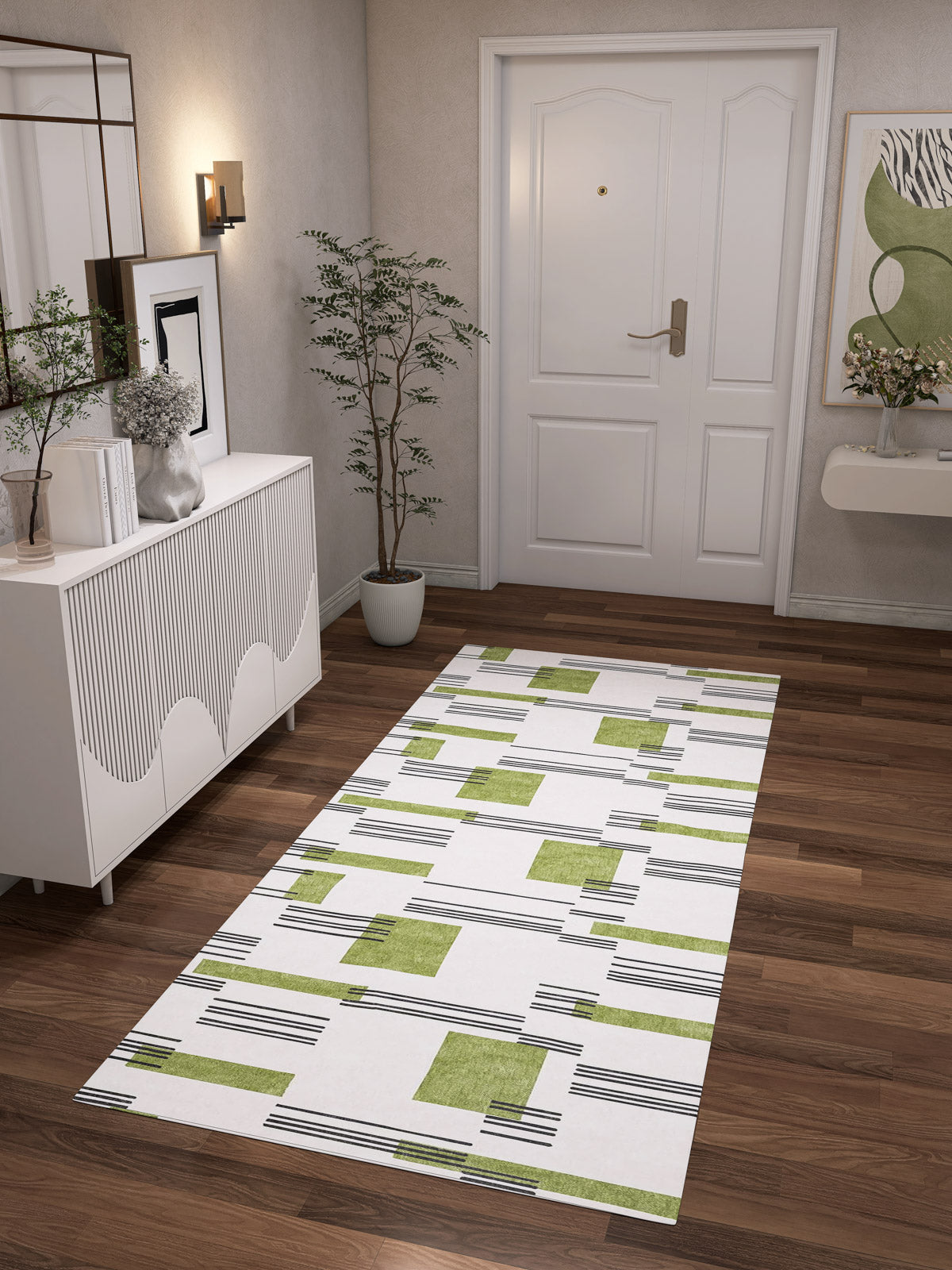 A modern hallway with wood flooring, a white sideboard, potted plant, abstract art, and the Faded Treasure - Washable Rug - JRN46 leading to a white front door with gold hardware.