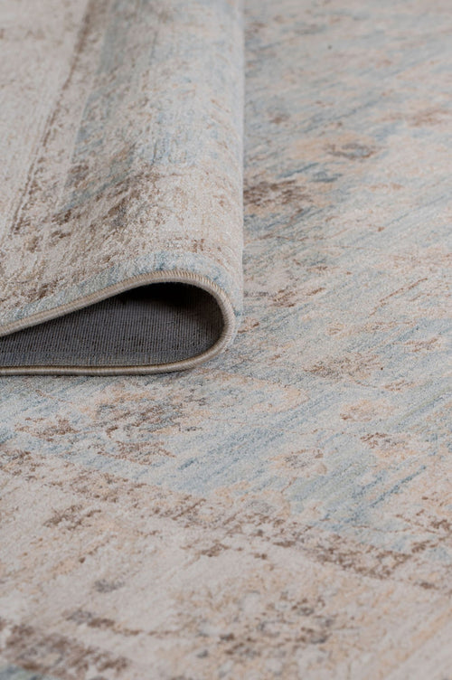 Load image 1 in gallery view. A close-up of the Faded Azure - Area Rug - APX2941 shows its blue and beige Persian-inspired abstract pattern with a textured underside, making it a stylish choice for any living room.