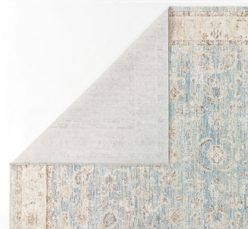 Load image 1 in gallery view. A close-up of the Faded Azure - Area Rug - APX2941 shows its blue and beige vintage-style pattern with a folded corner revealing a plain, light backing—an intricate design ideal for the living room.