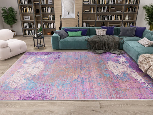 Load image 1 in gallery view. A modern living room with a large turquoise sectional, purple and green pillows, a white armchair, bookshelves, and the Faerie Weave - Washable Rug - JRS005—ideal for high-traffic areas—on light wood floors.