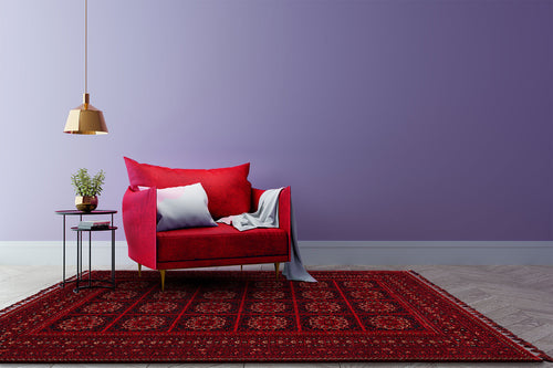 Bild 1 in Galerieansicht laden. A modern living room featuring a red velvet sofa, white and gray pillows, light throw, potted plant on a side table, gold hanging lamp, Fire Ripple - Kilim - BHR03 rug with Turkish inspiration, and a lavender wall background.
