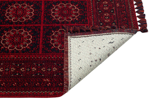 Bild 1 in Galerieansicht laden. The Fire Ripple - Kilim - BHR03 features a red patterned chenille weave with ornate designs. One corner is flipped, showing the plain white underside with minimal decoration.