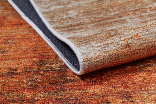 Load image 1 in gallery view. A close-up of the Fluffy Brushed - Washable Rug - JR584 (Custom Size) in orange with warm brown tones, showing a folded corner that reveals its dark textured underside and neat stitching—perfect for high-traffic areas.