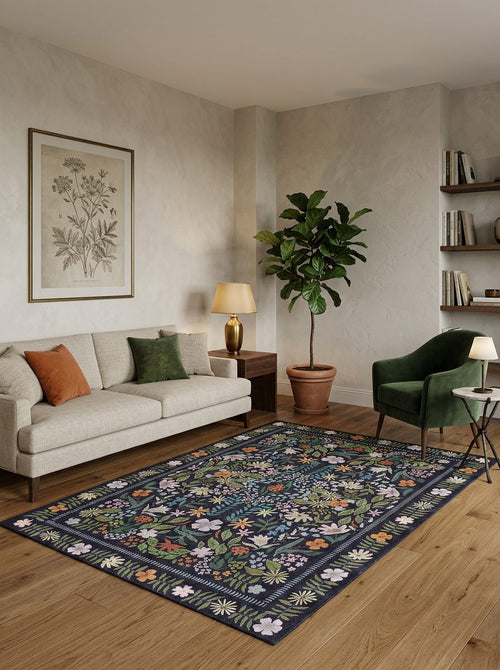 Load image 1 in gallery view. Dark navy rug with a colorful floral and botanical pattern, styled in a modern living room.