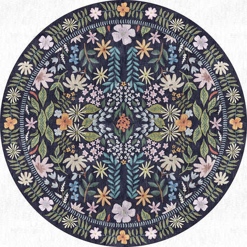 Load image 1 in gallery view. Round navy blue rug featuring a symmetrical botanical pattern of multicolored wildflowers and foliage.