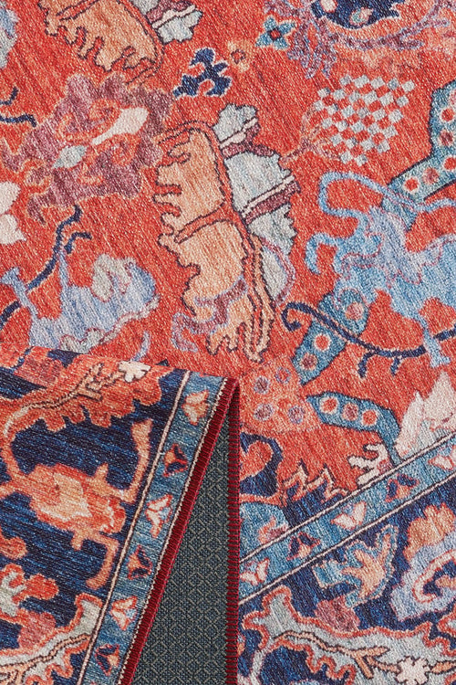 Load image 1 in gallery view. A close-up of the Galea Turkish-Design Coral Washable Rug (LCC3027) with intricate red, blue, and beige floral patterns. Folded corner shows textured underside—perfect for high-traffic areas and easy to clean.