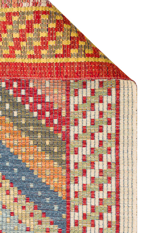 Load image 1 in gallery view. The Garnet Print - Washable Reversible Kilim - NMD10 features vibrant geometric patterns in red, yellow, blue, green, and white with diagonal, checkered, and grid-like designs. Shown with a folded corner to display its reversible underside.