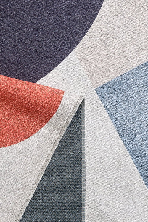 Load image 1 in gallery view. A close-up of the Geometric Zen Modern Washable Rug - MDJ002 (Custom Size) in navy, red, light blue, and gray on cream. The folded corner shows the underside, highlighting its durability for high-traffic areas.
