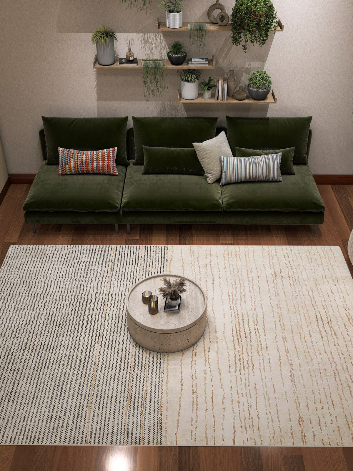 A modern living room with a green velvet sofa, assorted cushions, a round coffee table, the Gilded Charm Washable Rug (JRN26), and floating shelves with potted plants adorning the wall behind the sofa.