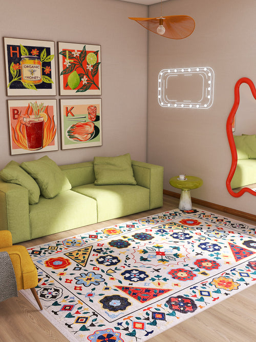 Load image 1 in gallery view. A colorful living room features a green sofa, the Global Gathering - Washable Rug - JR608 ideal for high-traffic areas, vibrant wall art, an orange-framed mirror, and a small round side table with a book, all in natural light.