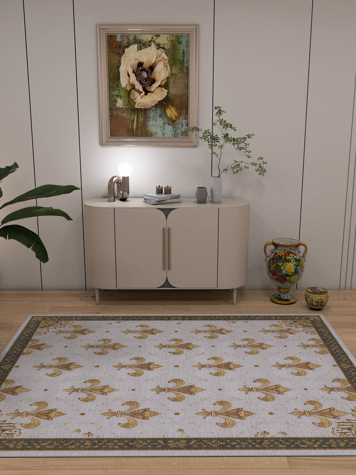 A modern room features a white cabinet, small lamp, and plant. Above is a large floral painting. The Golden Crest Washable Rug (JRS015) with gold patterns covers the light wood floor—ideal for allergy-sensitive, high-traffic areas.