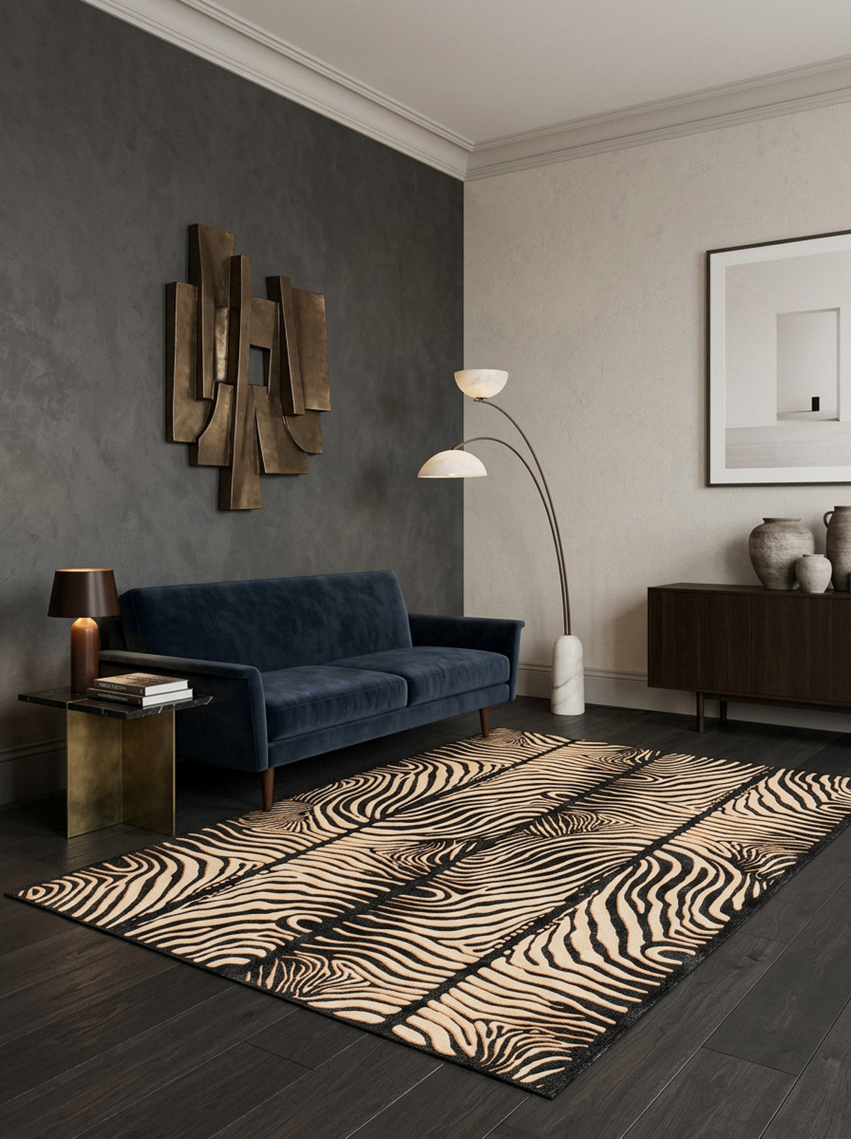A modern living room with dark wood floors, the Gossamer Fade washable rug (JRN44), a navy velvet sofa, gold abstract wall art, a brass side table with lamp, a floor lamp, and a sideboard with vases and framed art.