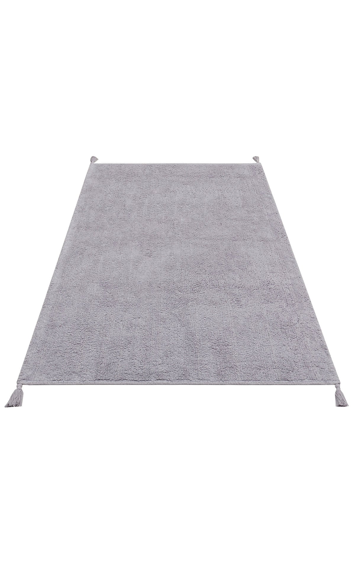 The Grey Snug - Washable Shaggy - CBNPLAIN is a rectangular, light gray cotton rug with a soft texture and tassels at each corner, ideal for modern bedrooms. Displayed on a white background.