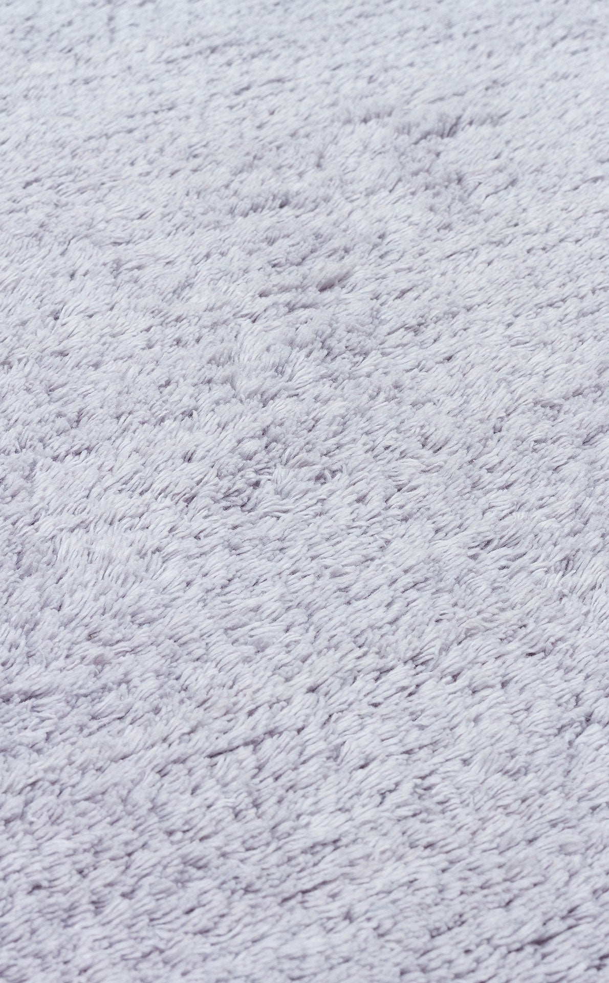 Close-up of the Grey Snug - Washable Shaggy (CBNPLAIN), a light gray, plush, textured rug—perfect for adding cozy comfort and modern style to any bedroom.