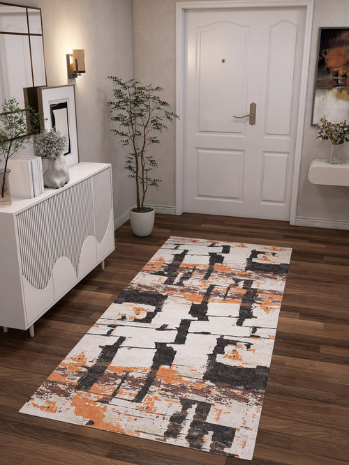 Bild 1 in Galerieansicht laden. A modern hallway with a white front door, wood floors, and the Heirloom Touch - Washable Rug - JRN42 (Custom Size) in white, black, and orange. A white console, plant, and art on beige walls complete this chic space—ideal for high-traffic areas.