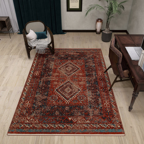 Load image 1 in gallery view. A cozy study with a large Heritage Blend - Washable Kilims - AND02 area rug in red and blue, a dark wooden desk and chair, a cushioned cane armchair, potted plants, dark green curtains, pale walls, and light wood flooring
