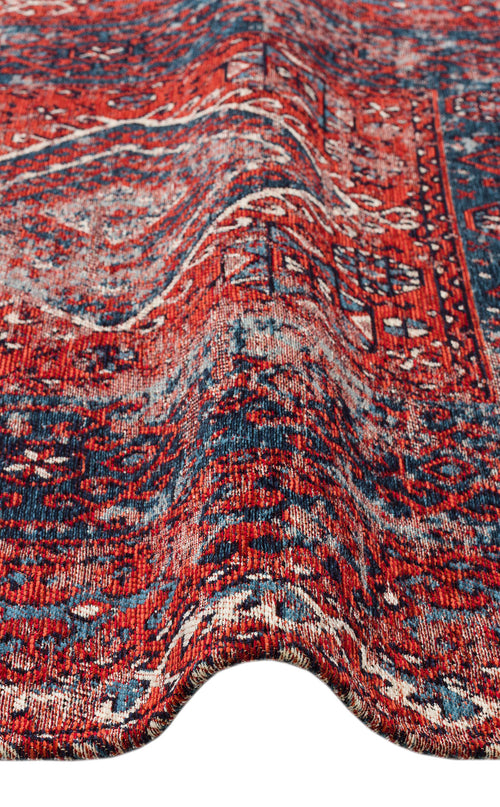Load image 1 in gallery view. A close-up of the Heritage Blend - Washable Kilims - AND02 rug showcases its red and blue intricate patterns, visible texture, and a gentle wave along the surface.
