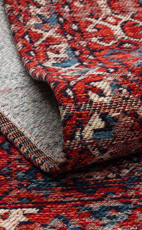 Load image 1 in gallery view. A close-up of the Heritage Blend - Washable Kilims - AND02 shows its red, blue, and cream pattern with a folded corner, highlighting the texture and intricate woven design