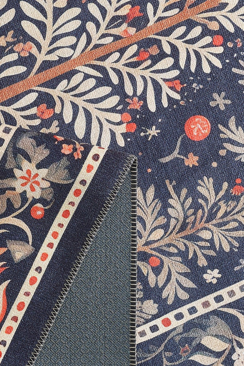 Load image 1 in gallery view. Close-up of the Holiday Heart Washable Area Rug - MDJ001 in blue, featuring a botanical pattern with cream and orange leaves, branches, and red berries. The fold reveals the plain blue underside and detailed edge stitching—ideal for high-traffic areas.