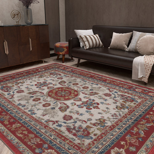 Load image 1 in gallery view. A living room with a dark brown sofa topped with assorted cushions, a wood cabinet, and the Imperial Rose - Washable Rug - JRS023 featuring red, blue, and beige floral patterns. A patterned round ottoman sits near the sofa.