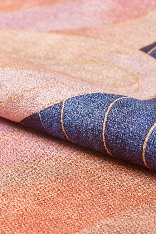 Load image 1 in gallery view. A close-up of the Iris Abstract Floral Washable Rug - MDJ009 (Custom Size) shows curved lines in pink, peach, and dark blue with fine gold accents. Partially rolled to highlight its thick, soft texture—perfect for high-traffic areas.