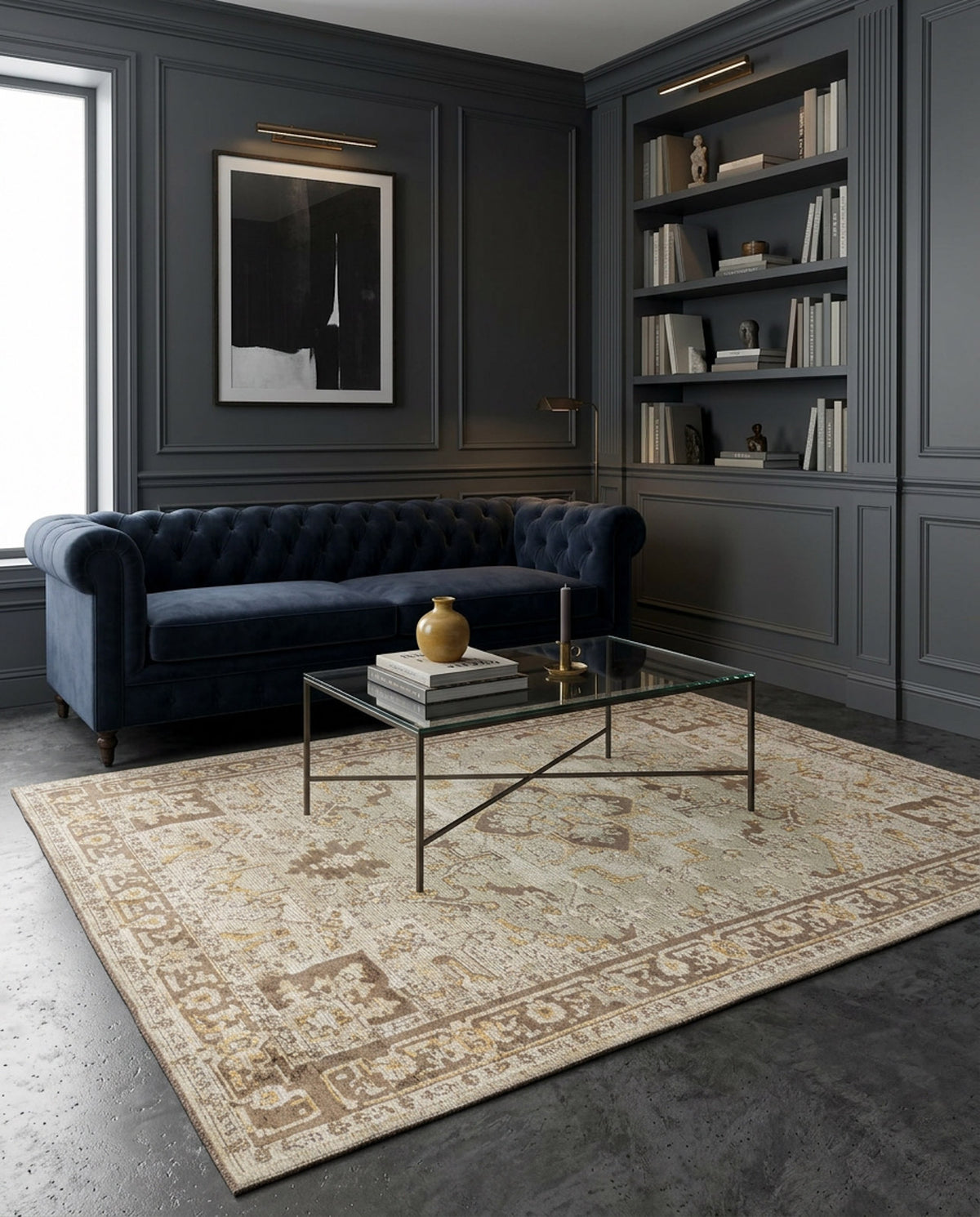 A modern living room with dark gray paneled walls, a navy blue tufted sofa, built-in bookshelves, a glass coffee table with books and a vase, and the Ivory Medallion Area Rug APX1932 over the concrete floor.