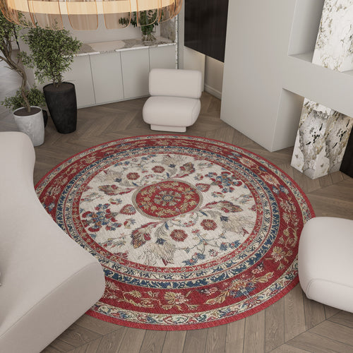 Load image 1 in gallery view. Round rug with a red, blue, and cream floral medallion pattern, styled in a modern living room.