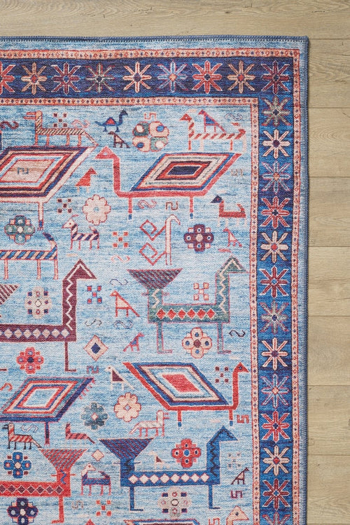 Load image 1 in gallery view. The Birdwatcher's Dream Blue Washable Rug - LCC3020 features geometric animal and floral patterns in red and cream, a star motif border, and is perfect for high-traffic areas on light wooden floors.