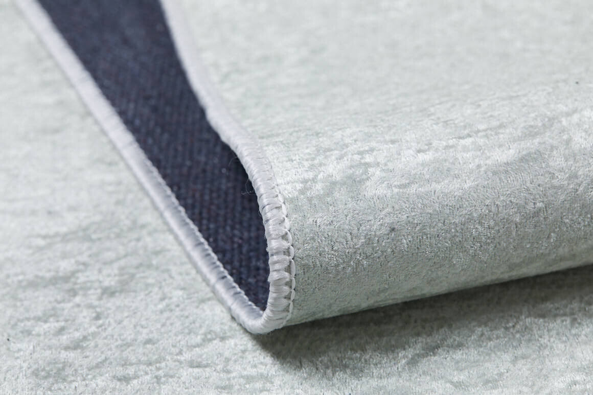A close-up of the Joyful Elephant - Machine-Washable Rug JRC026 (Custom Size) in light gray, showing its soft, velvety flat weave, white stitched edging, and dark textured underside—an allergy-friendly choice for your home.