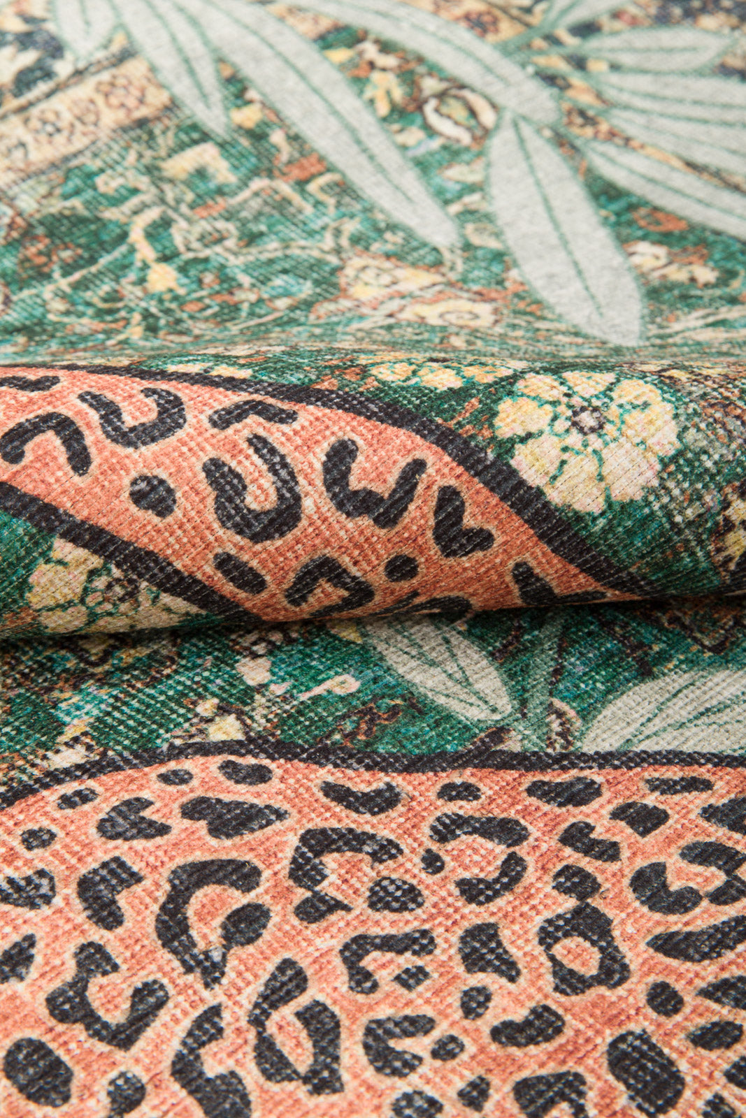 Close-up of the Jungle Ember - Washable Rug (JR0047) shows its woven, washable texture with green leafy patterns and orange sections with black leopard spots—highlighting the rug’s vibrant detail and design.