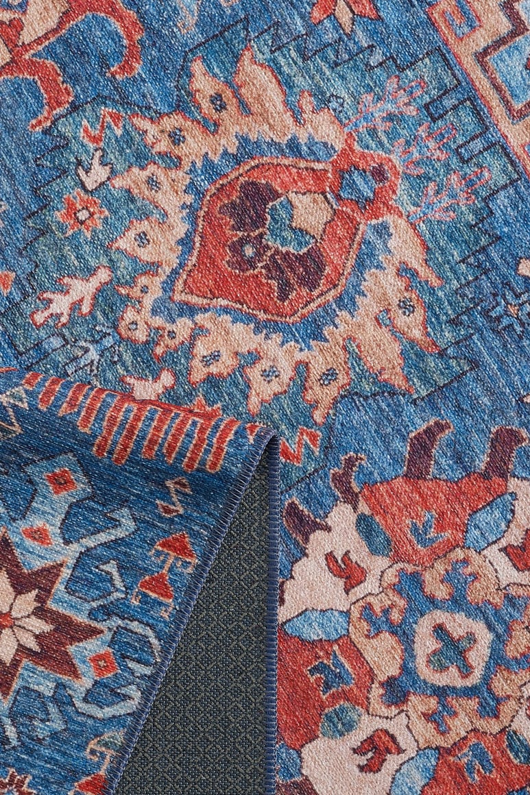 A close-up of the Kaleidos Authentic Blue Washable Rug - LCC3028 (Custom Size) shows intricate geometric and floral patterns in red, beige, and orange. A folded corner reveals its textured backing—ideal for high-traffic areas.