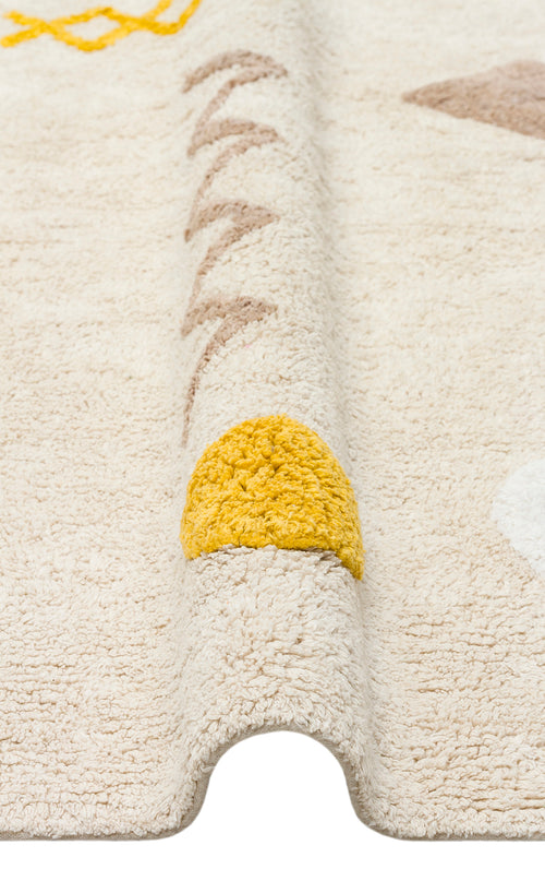 Load image 1 in gallery view. A close-up of the Little Dream - Washable Shaggy - CBN12 cotton rug, showing its folded edge and simple yellow, beige, and white geometric designs. The prominent yellow semicircle makes it ideal as a cozy kids’ room rug.