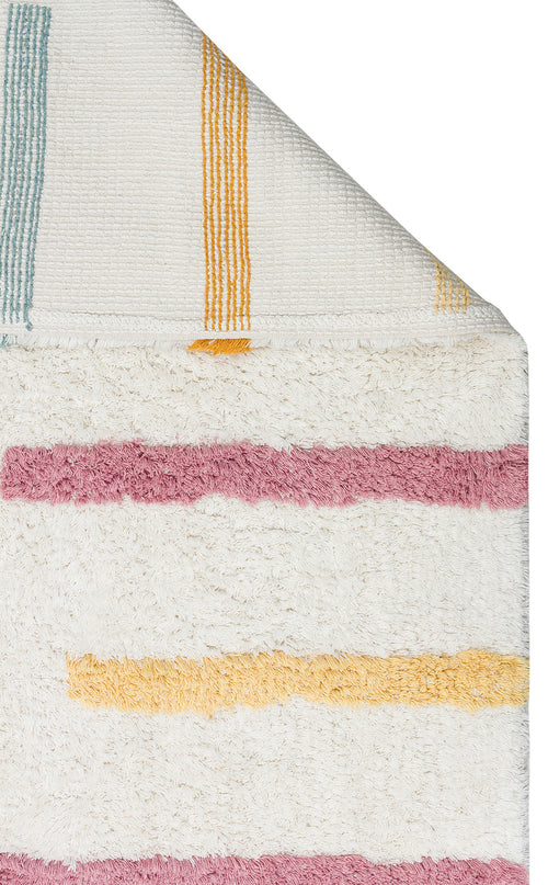 Load image 1 in gallery view. The Little Steps - Washable Shaggy - CBN03 is a white textured rug with horizontal pink and yellow stripes. One corner folds over to show the underside with thin vertical yellow and teal stripes—ideal for a children’s room.