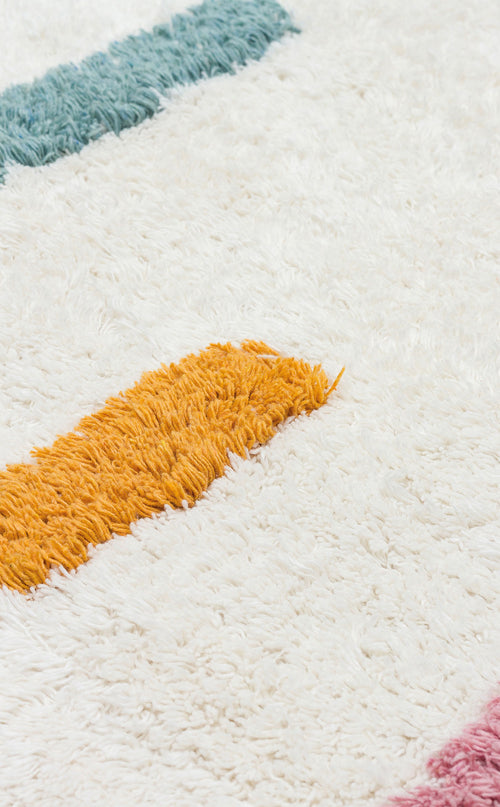 Load image 1 in gallery view. A close-up of the Little Steps - Washable Shaggy - CBN03 rug, featuring a soft white base with thick teal, yellow, and pink stripes. This multicolour shaggy rug's fluffy texture is ideal for brightening any children’s room.