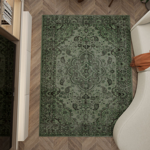 Load image 1 in gallery view. Sage green traditional rug with a dark floral medallion pattern, styled in a living room with herringbone flooring.