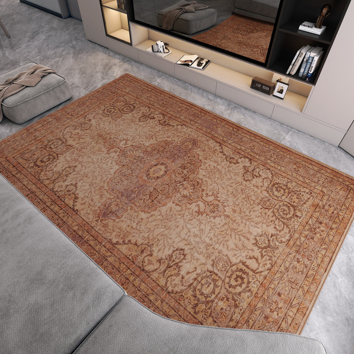 A living room featuring the Chateau Elegance - Washable Rug - JRN1018 (Custom Size) with light brown borders on a gray marble floor, paired with a gray sectional, modern shelving, and a large mirror reflecting the stylish decor.