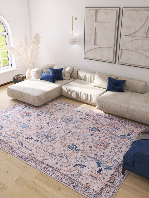 Load image 1 in gallery view. A bright living room with a cream sectional sofa, blue accent pillows, the Luminary Beige Gray Washable Rug (LCC3023), pampas grass in a vase, abstract wall art, and natural light from an arched window.