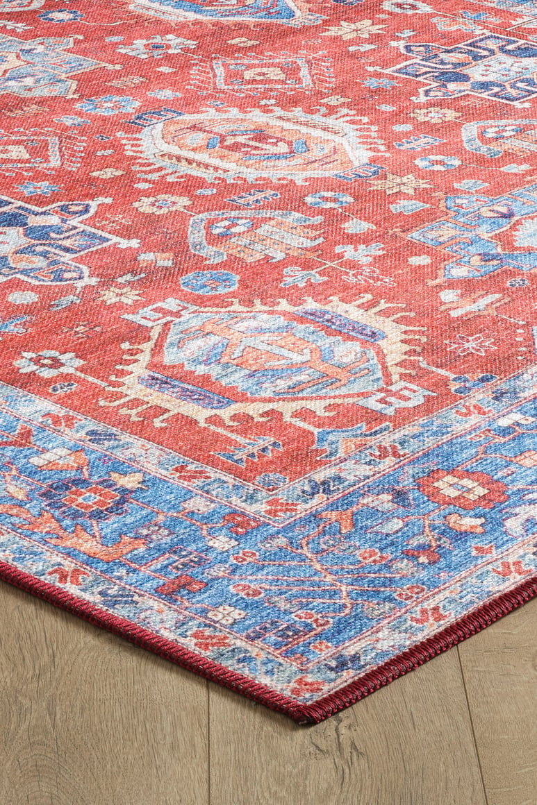 The Lunavale Red Blue Washable Rug (LCC3007) is displayed on a light wood floor, featuring intricate blue, white, and beige geometric patterns with a decorative border—ideal for high-traffic areas.