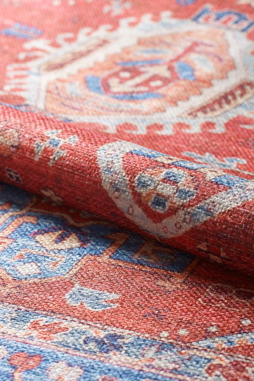 Bild 1 in Galerieansicht laden. A close-up of the Lunavale Red Blue Washable Rug - LCC3007 shows its intricate blue, white, and beige geometric patterns and textured fabric—perfect as a washable rug for high-traffic areas.
