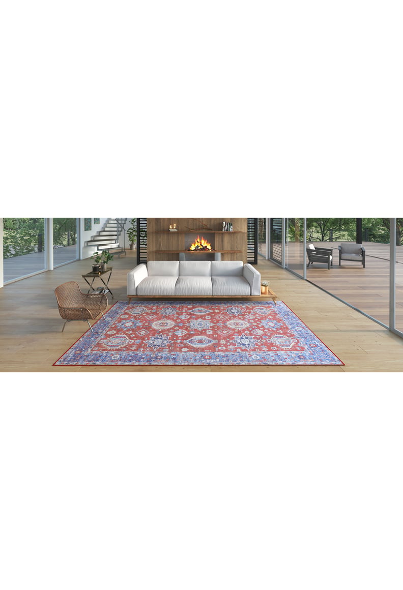 A modern living room with a white sofa, round chair, wooden fireplace, glass walls, and the Lunavale Red Blue Washable Rug - LCC3007 (Custom Size) featuring purple patterns on light wood floors—ideal for high-traffic areas.