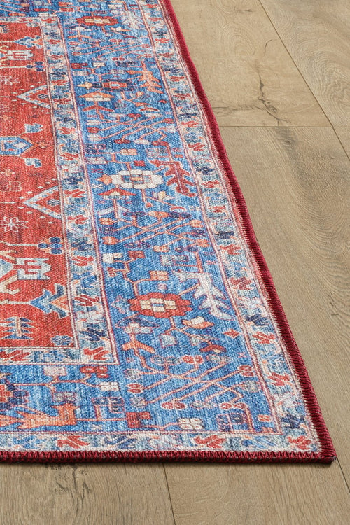 Load image 1 in gallery view. A close-up of the Lunavale Red Blue Washable Rug - LCC3007 (Custom Size), featuring colorful geometric patterns, perfect for high-traffic areas, shown on a light wooden floor.