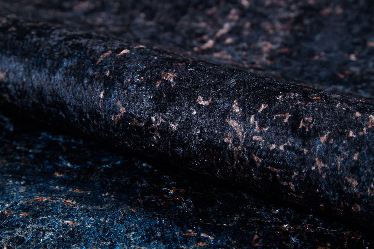 A close-up of the Luxurious Fleur - Washable Rug - JR1897 (Custom Size) highlights its dark, textured granite-inspired surface with blue, black, and brown speckles—perfect for high-traffic areas or pairing with bold décor.