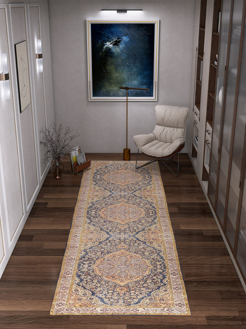 Load image 1 in gallery view. A hallway with wooden floors features the Majestic Crest - Washable Rug - JRN1015 (Custom Size) runner, a modern cushioned chair, floor lamp, vase with branches, and a large abstract painting under a picture light.